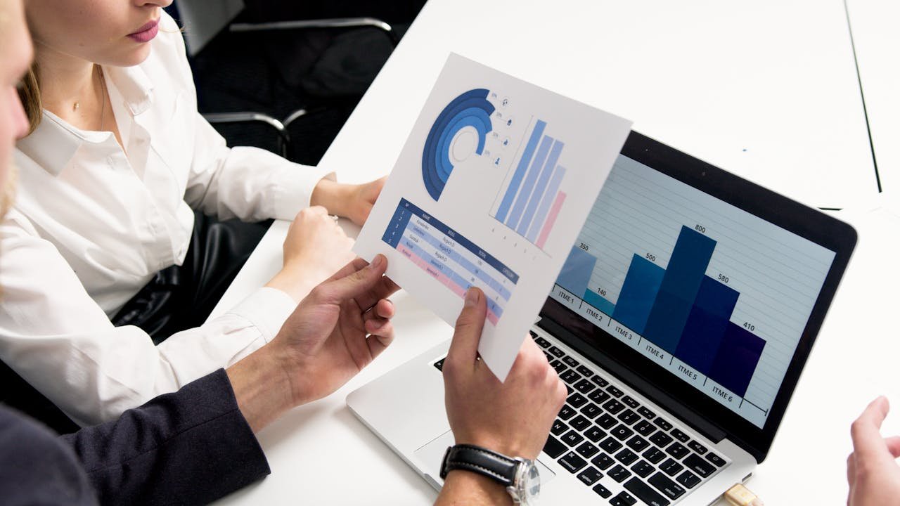 The Art of Drawing Readers In: Your attractive post title goes here Business professionals discussing data charts and graphs in a modern office setting.